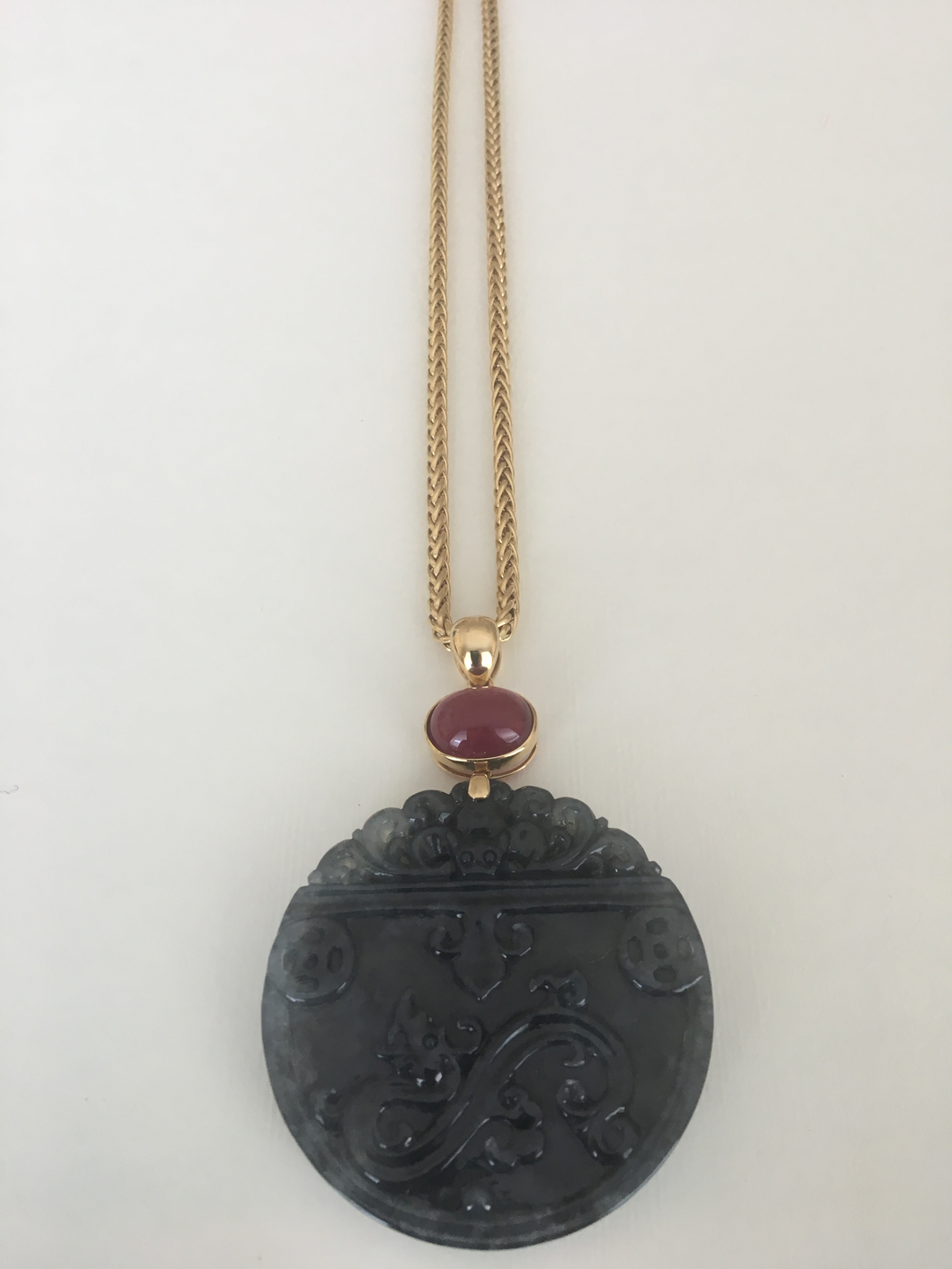 Carved charcoal jade pendant with rubellite in 18k yellow gold.